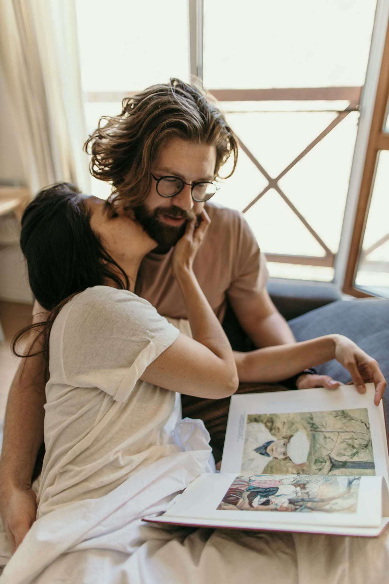 Cozy moment between a couple reading a vintage book together in bed.