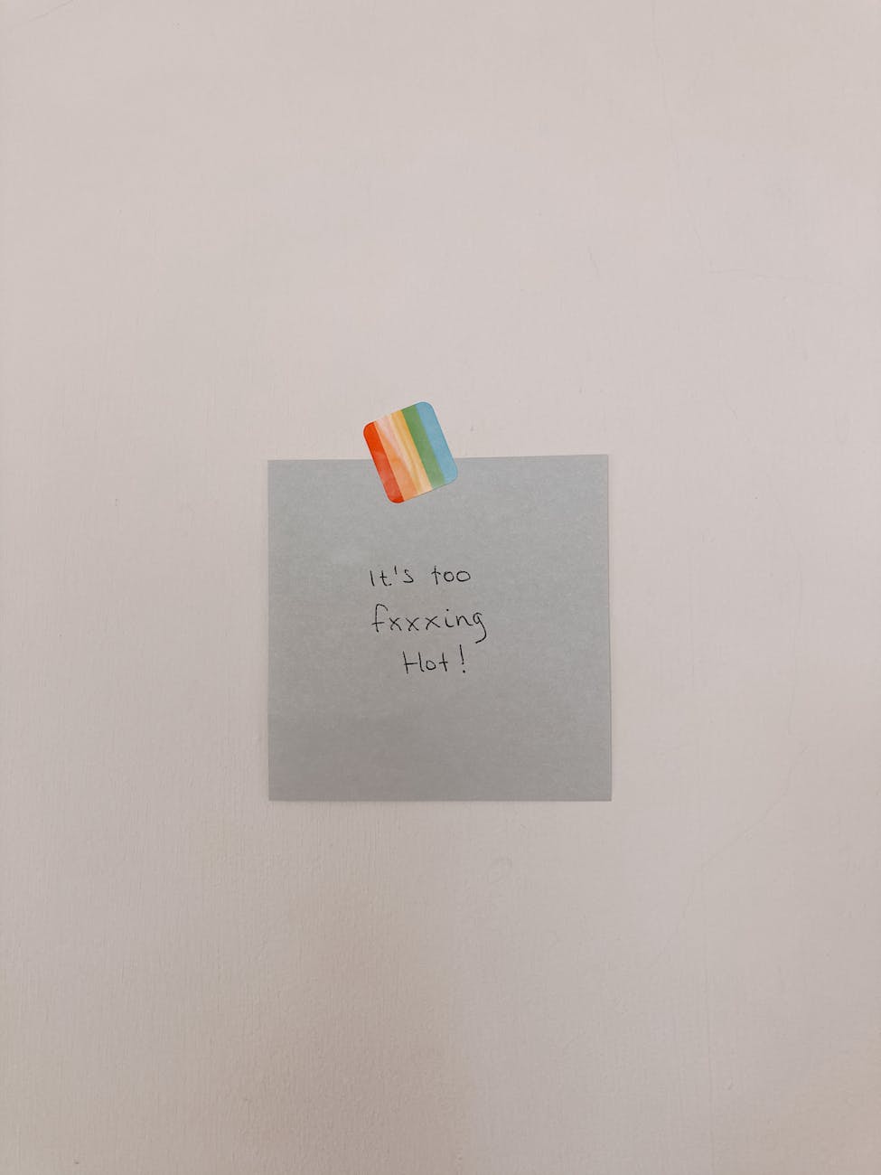 Post-it note with rainbow sticker displays message: 'It's too fxxxing hot!'