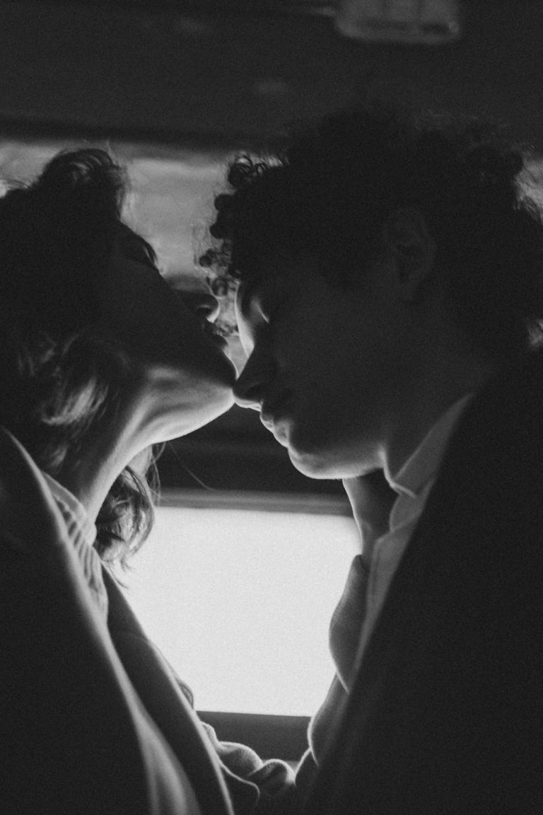 A romantic black and white moment featuring a couple in an intimate setting.