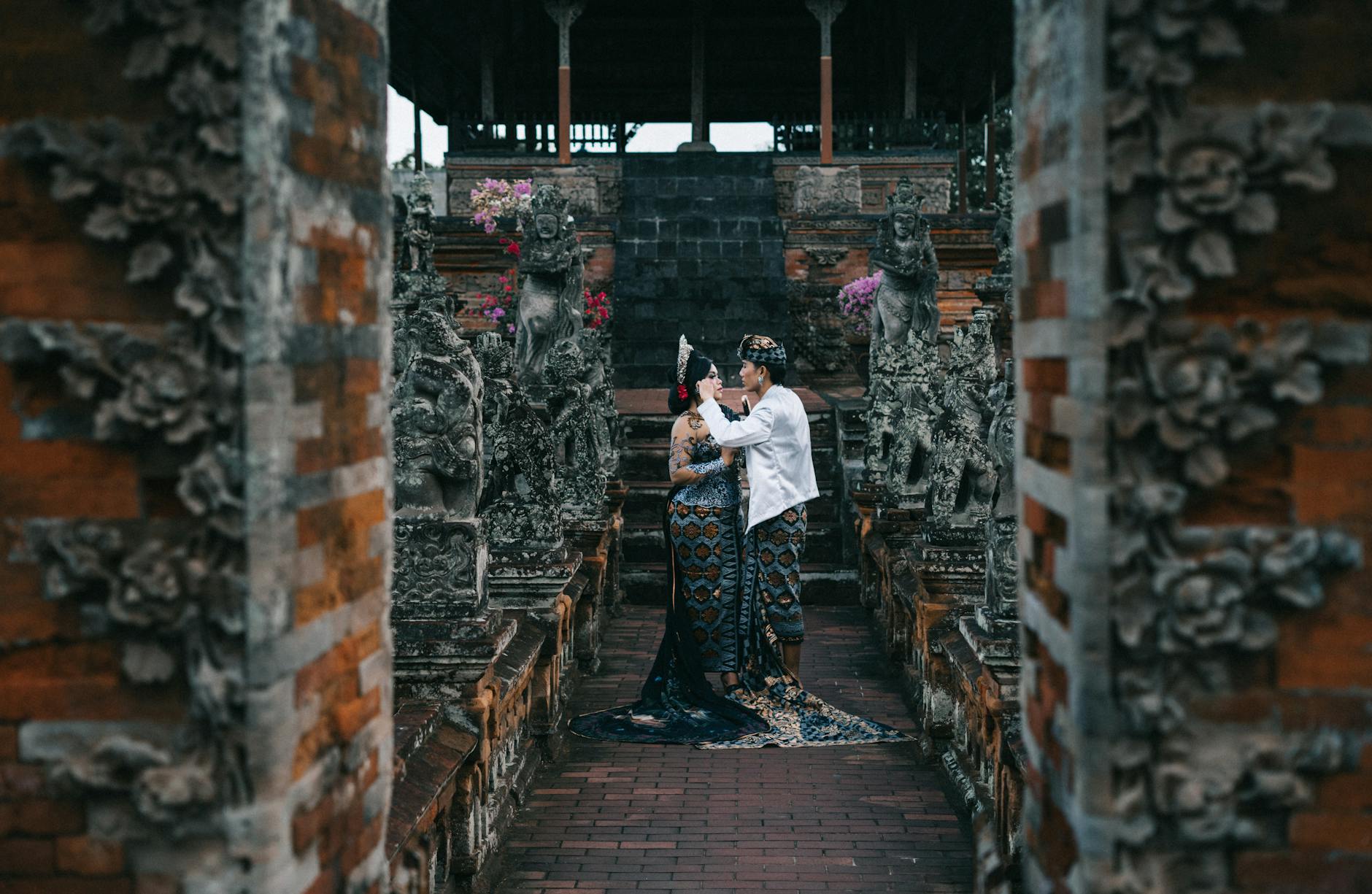 Asian couple in traditional wear at a temple, symbolizing cultural heritage and love.