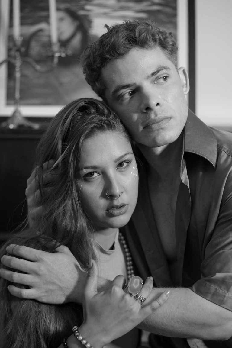 A dramatic black and white portrait capturing an emotional embrace between a couple.