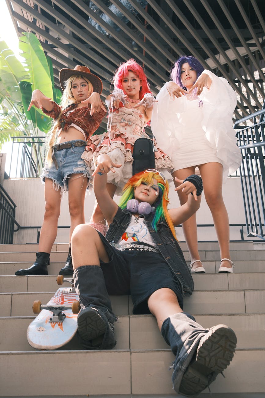 A vibrant cosplay group striking poses on outdoor stairs, showcasing unique costumes and hairstyles.