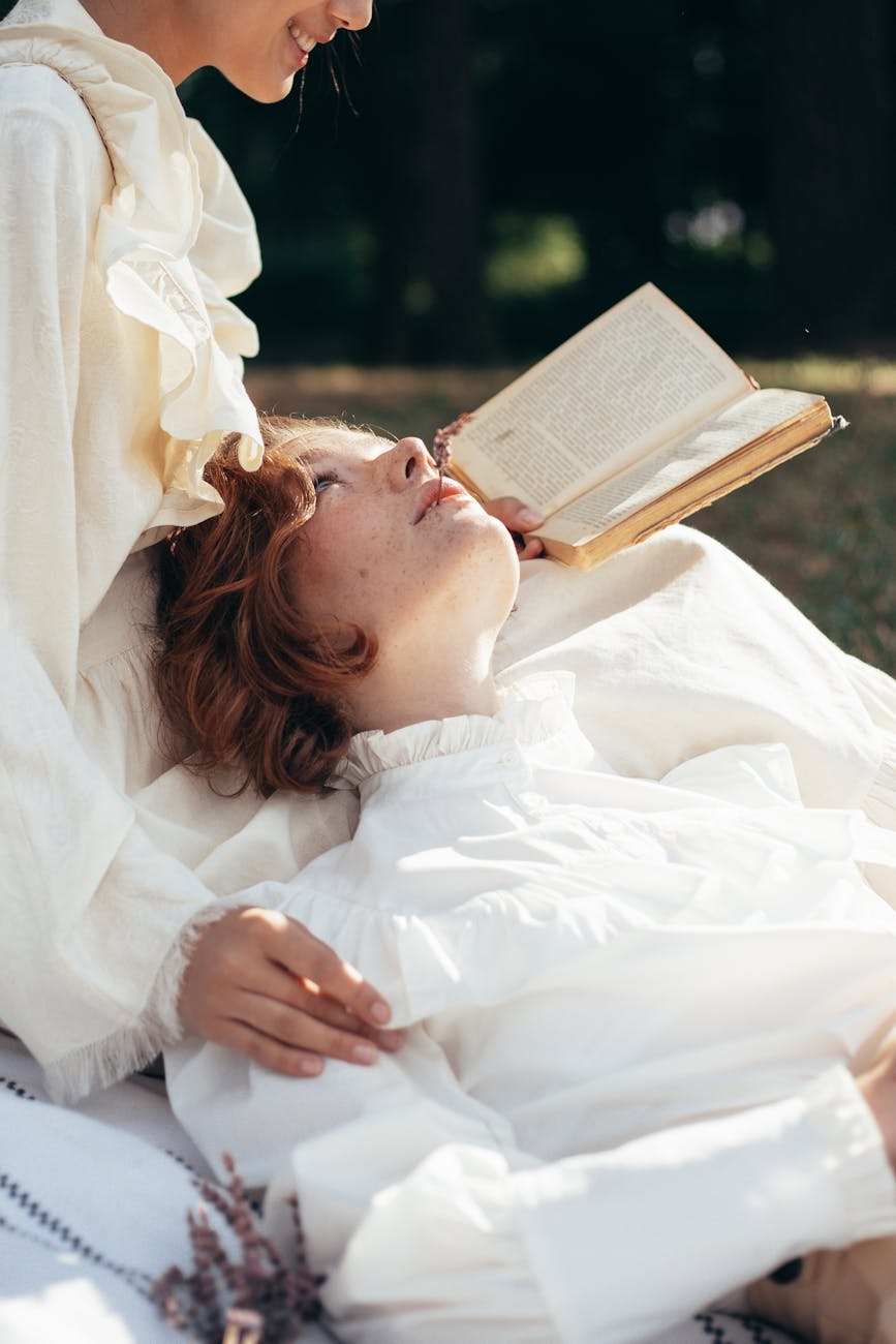 Romantic couple enjoying a book outdoors, embracing idyllic love and intimacy in nature.